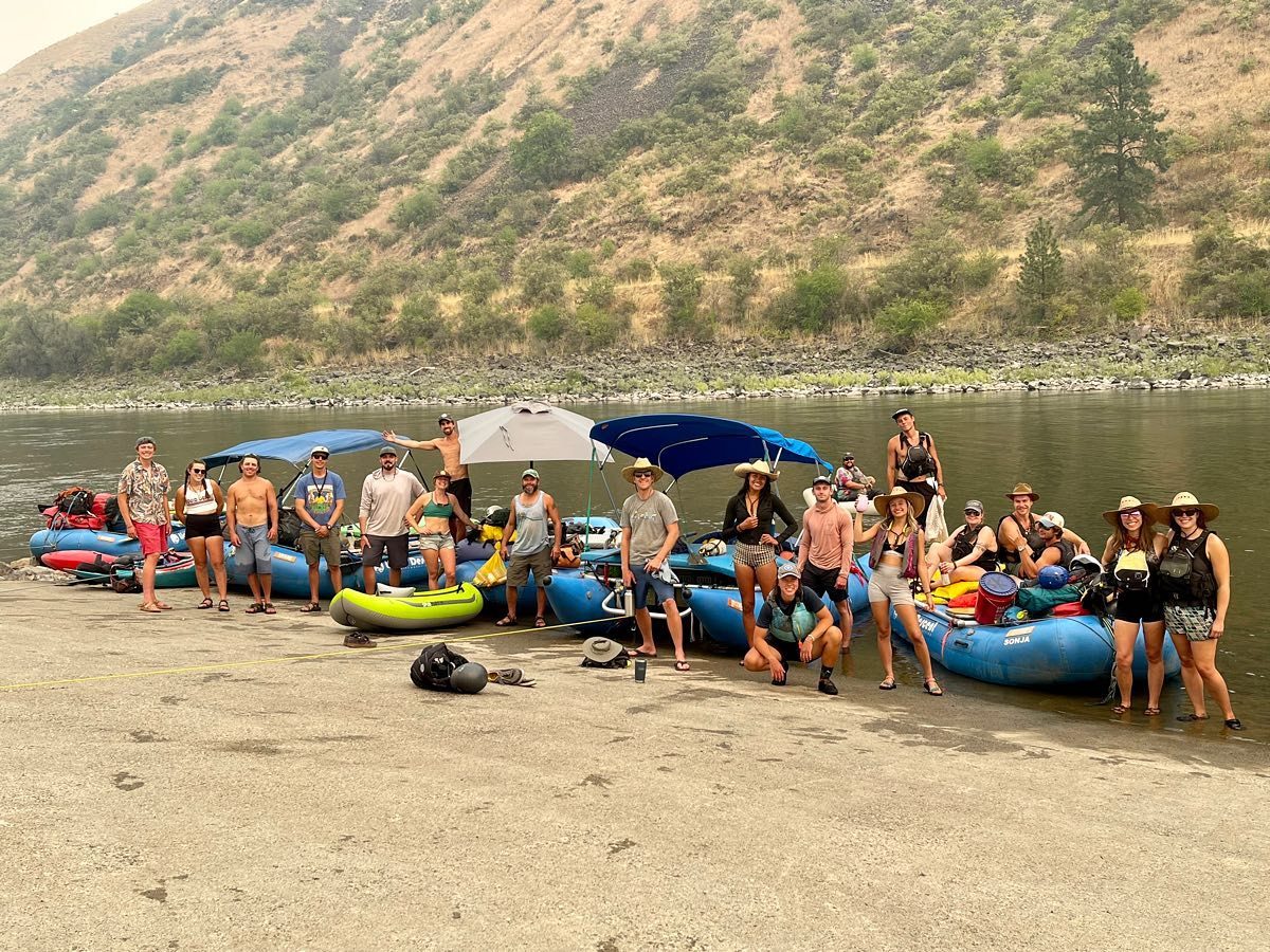 Happy rafting group gathered on the riverbank